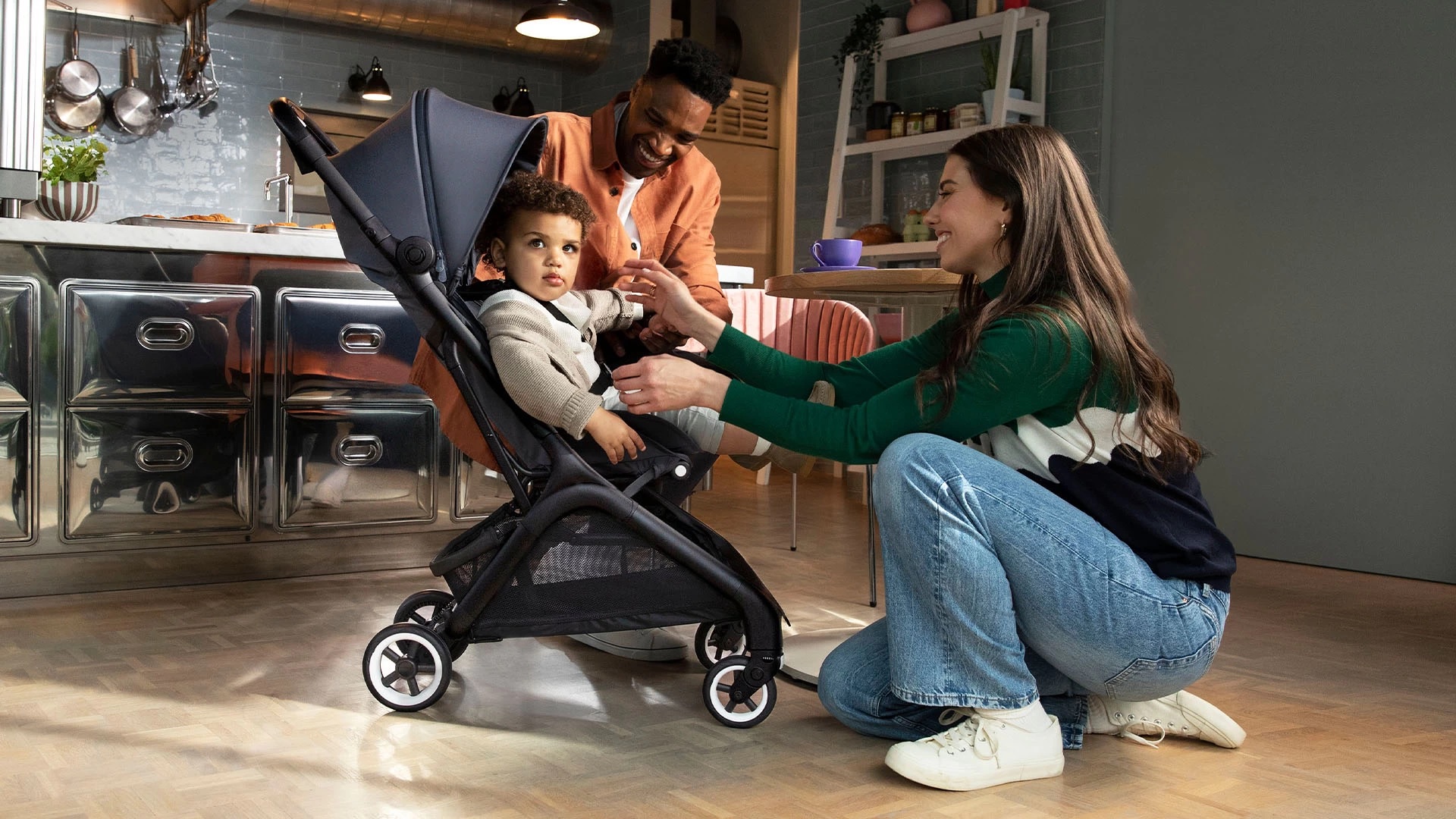 Rodzice sprawdzający wózek spacerowy, w którym znajduje się dziecko przed wyjściem na spacer