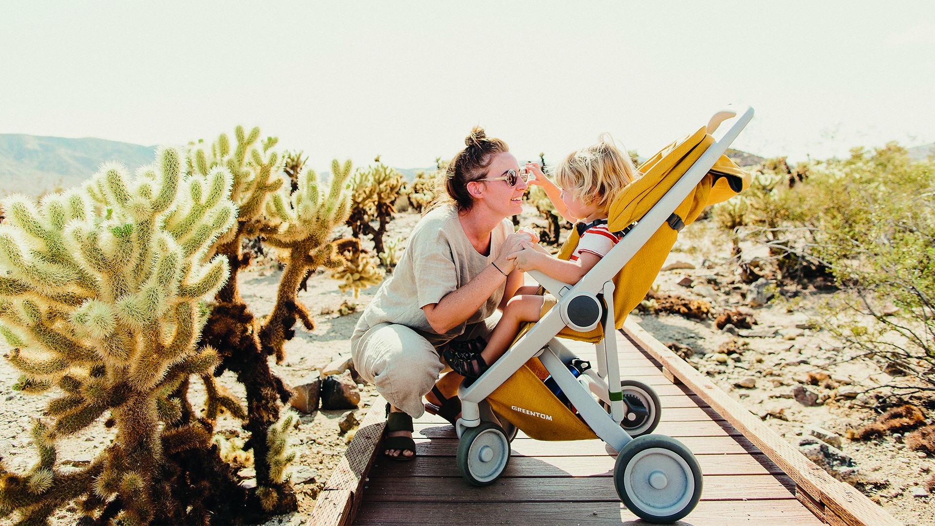 Mama bawiąca się z dzieckiem, które znajduje się w wózku spacerowym Greentom 